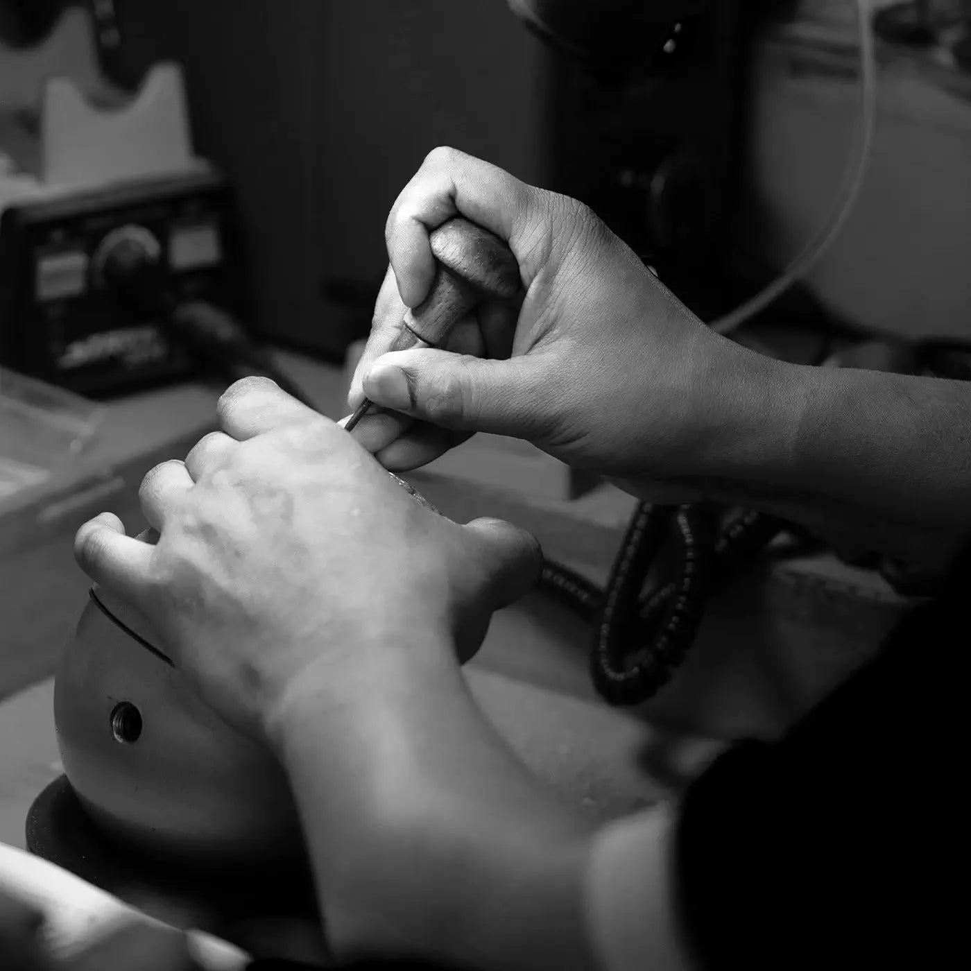Person using a tool on a ring in a workshop setting
