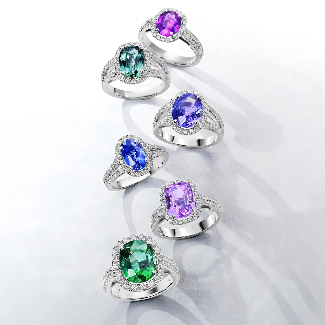 Set of six 18k whit gold rings with color  gemstones on a white background