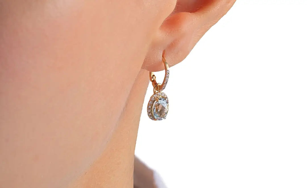 Sunrise, 18k yellow gold earrings with blue aquamarine gemstones on ear